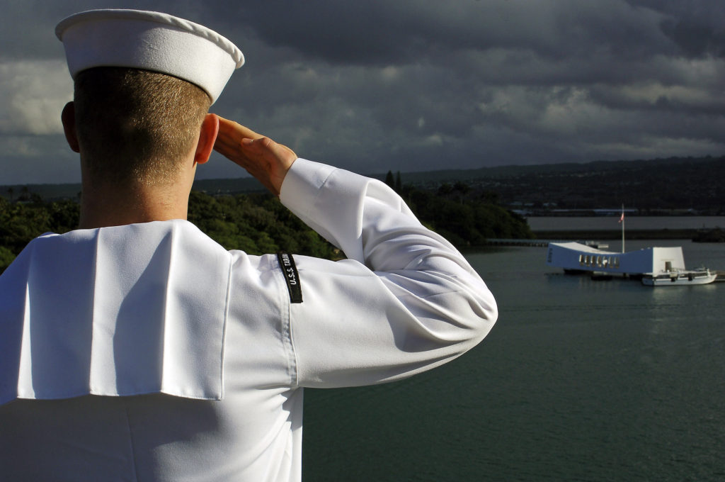 A Sailor attached to amphibious assault ship USS Tarawa (LHA 1) renders honors to the USS Arizona Memorial before mooring in Pearl Harbor, Hawaii. Tarawa and the embarked 11th Marine Expeditionary Unit (MEU) are on a regularly scheduled deployment to the Western Pacific Ocean. (U.S. Navy photo/Seaman David A. Brandenburg)